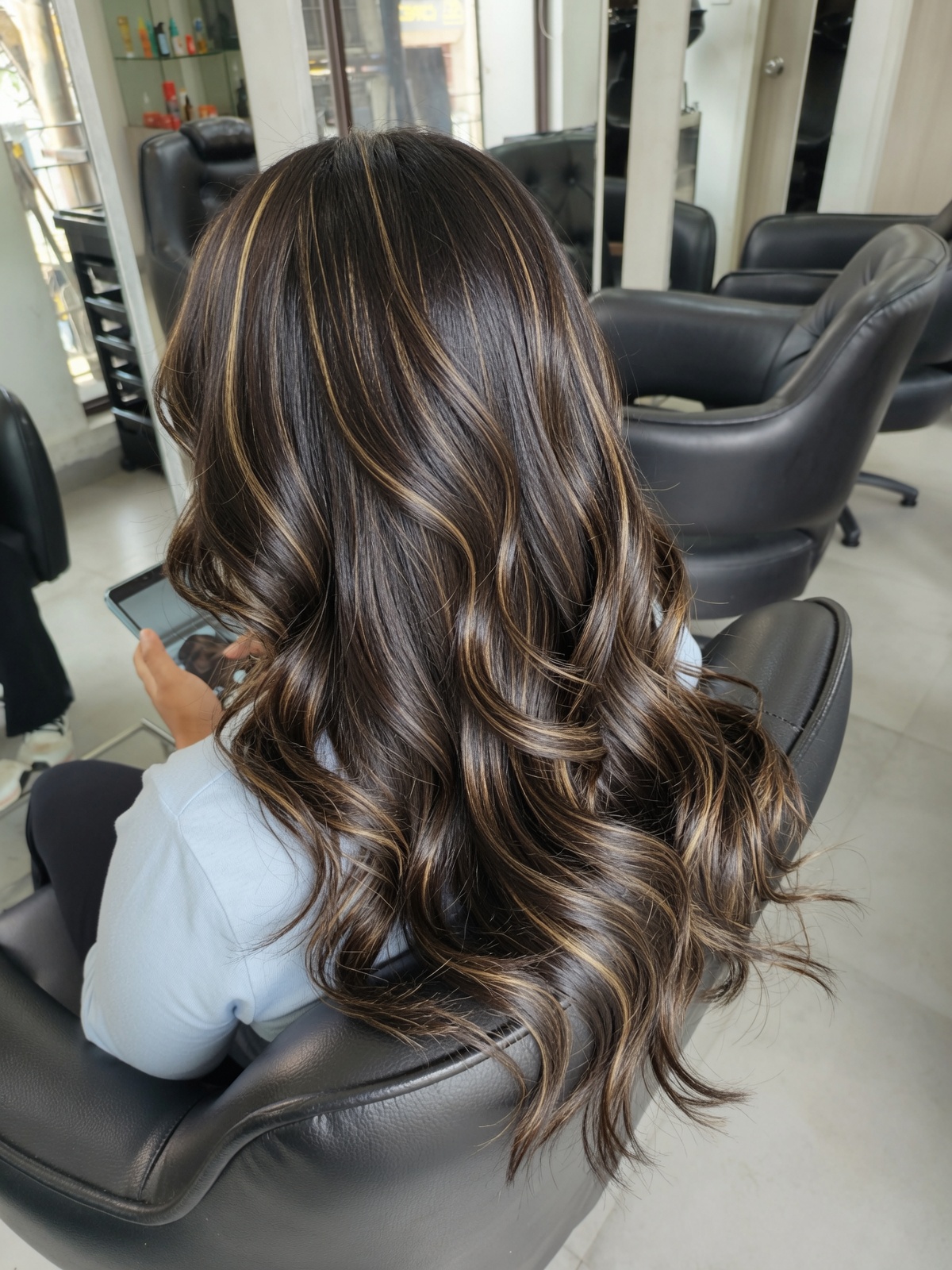 Glossy brunette waves with caramel highlights created at Salon Nayana